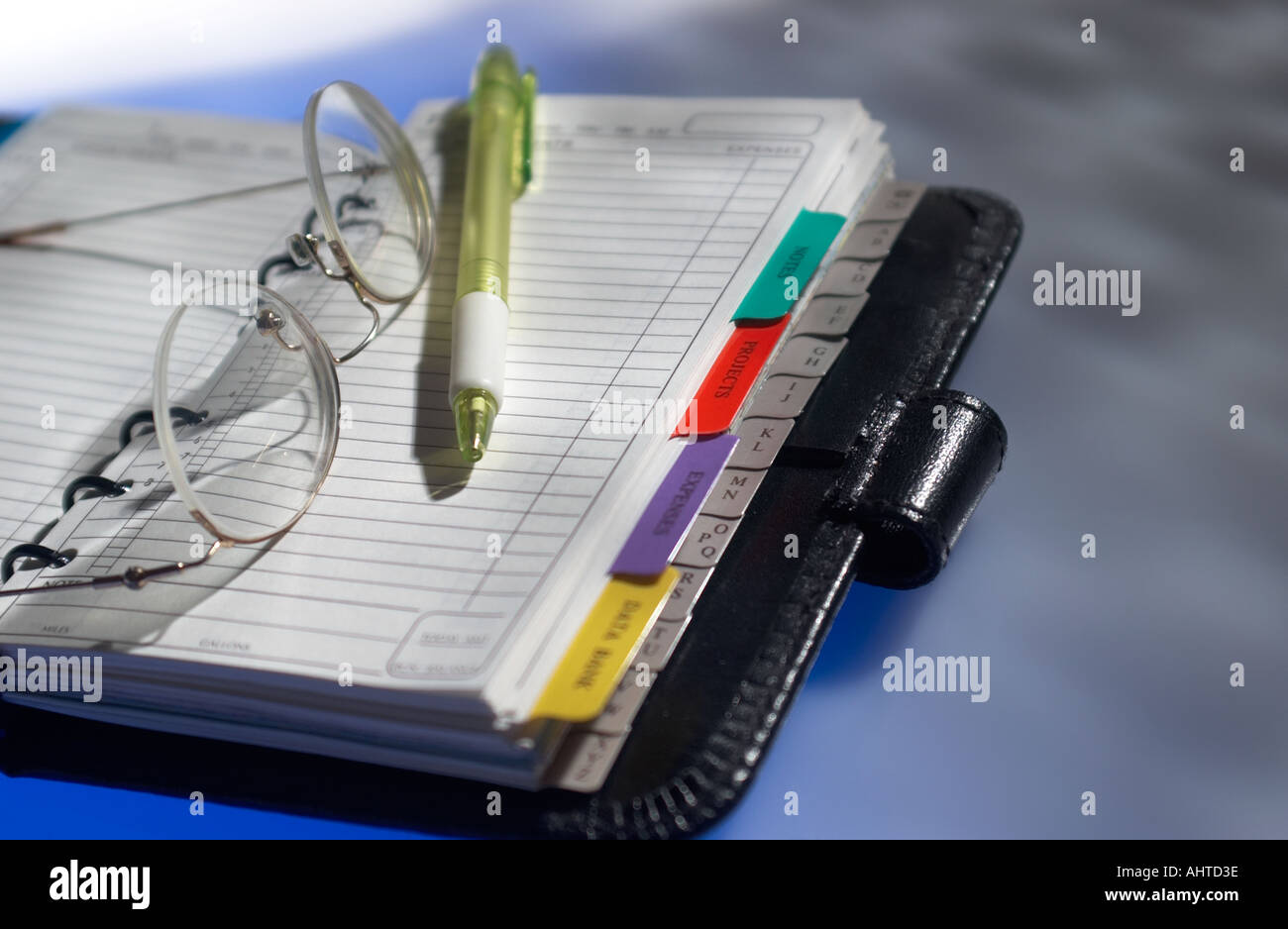 coloured pen and glasses on top of a filofax organiser Stock Photo