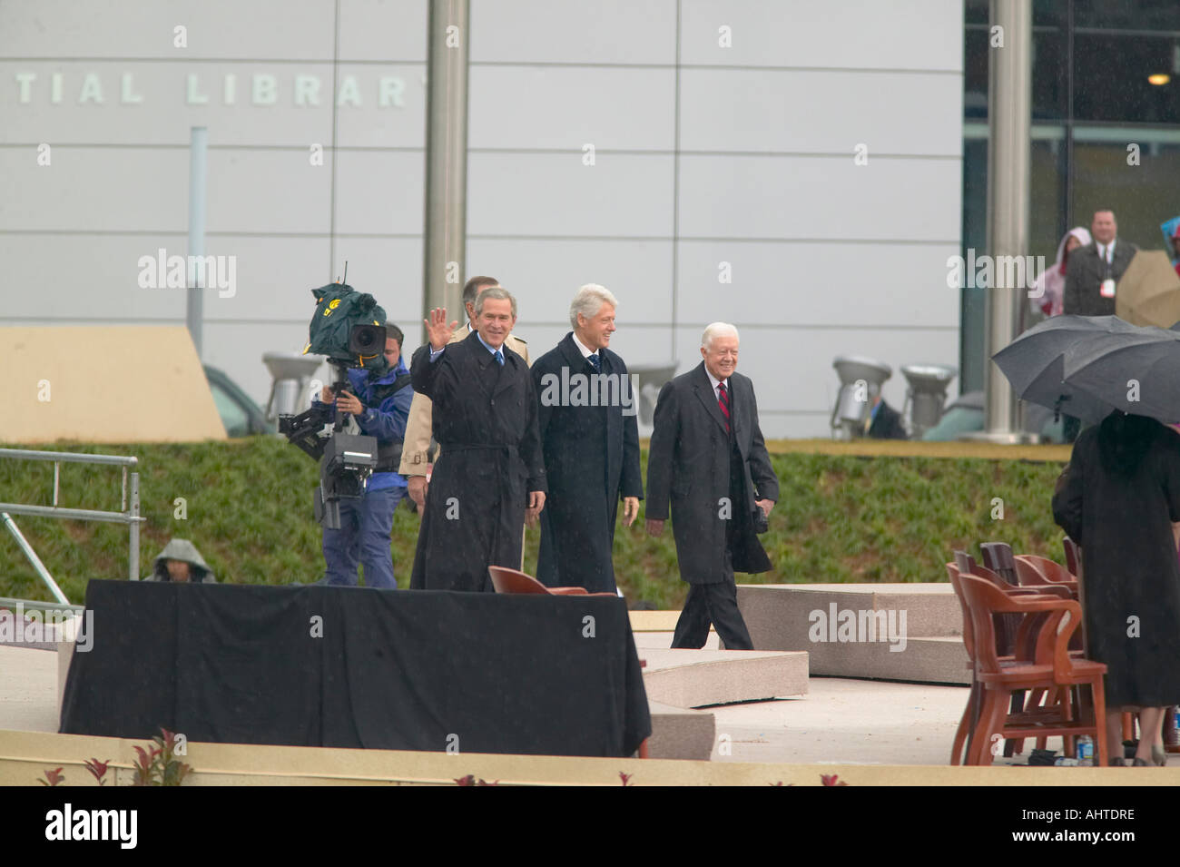 Former U S President Bill Clinton walks on the stage accompanied by a waving President George W Bush former presidents Jimmy Stock Photo