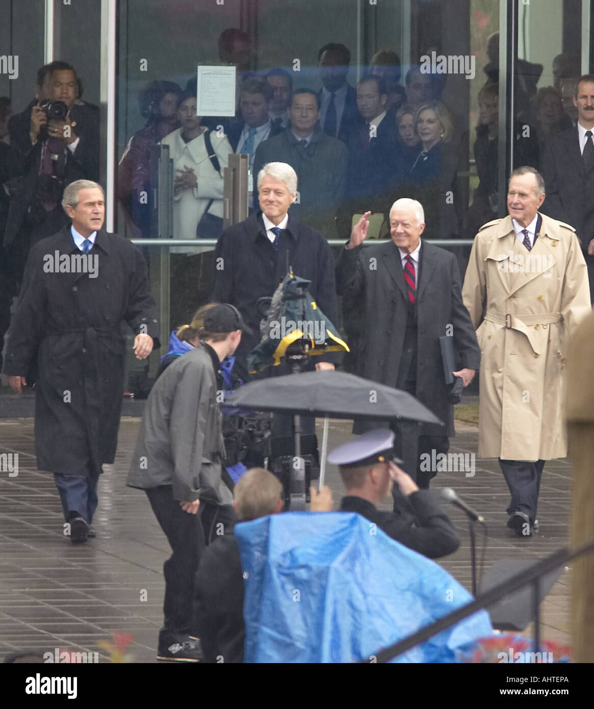 Former U S President Bill Clinton emerges from the library with President George W Bush former presidents Jimmy Carter and Stock Photo
