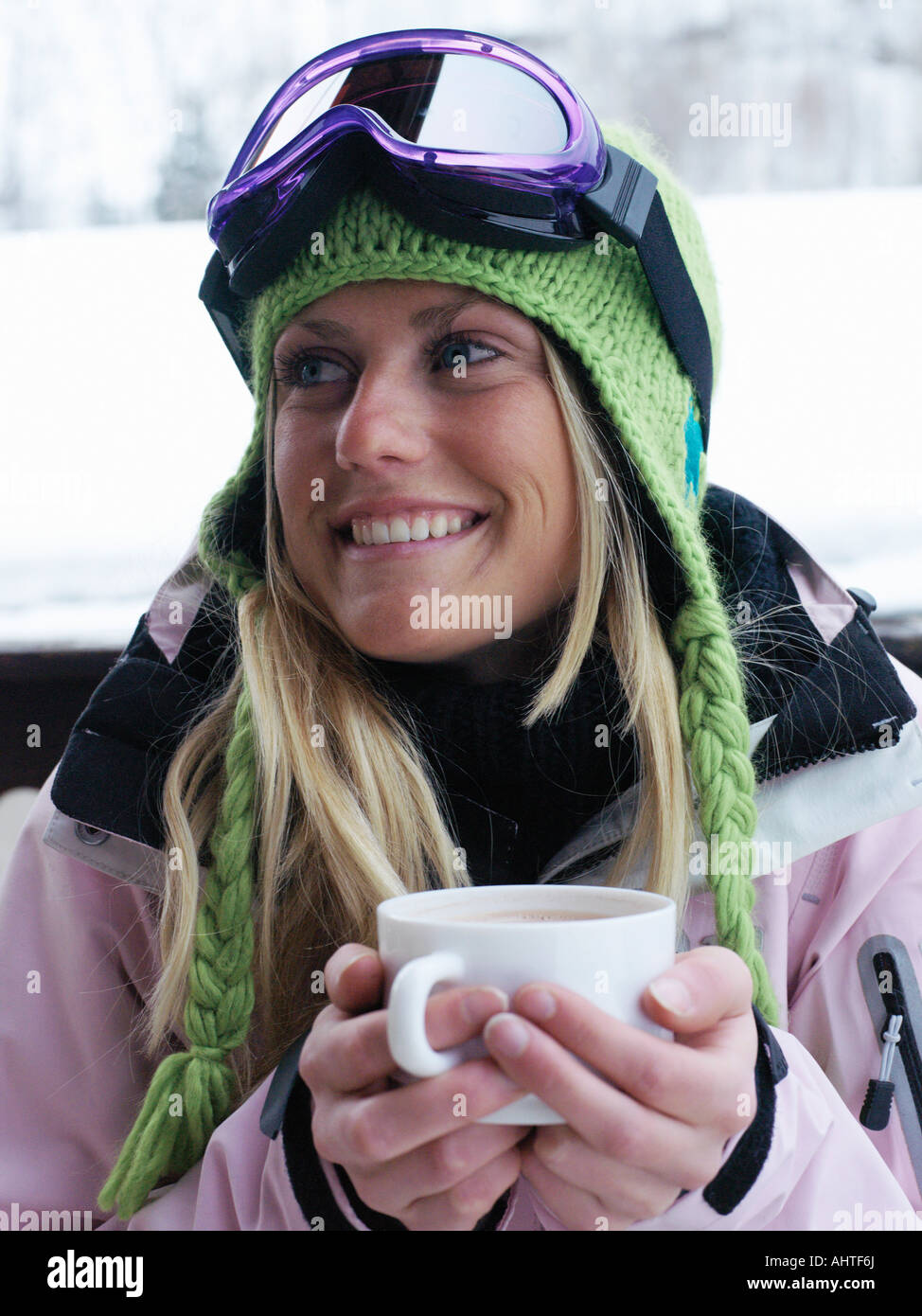 Young woman in ski-wear with cup of hot chocolate, close-up, portrait Stock Photo