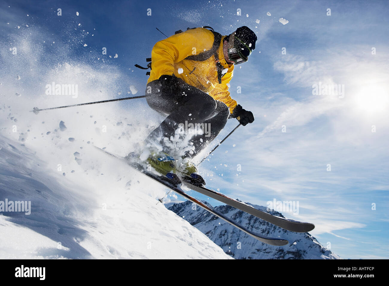 Male skiing over mountain ridge Stock Photo