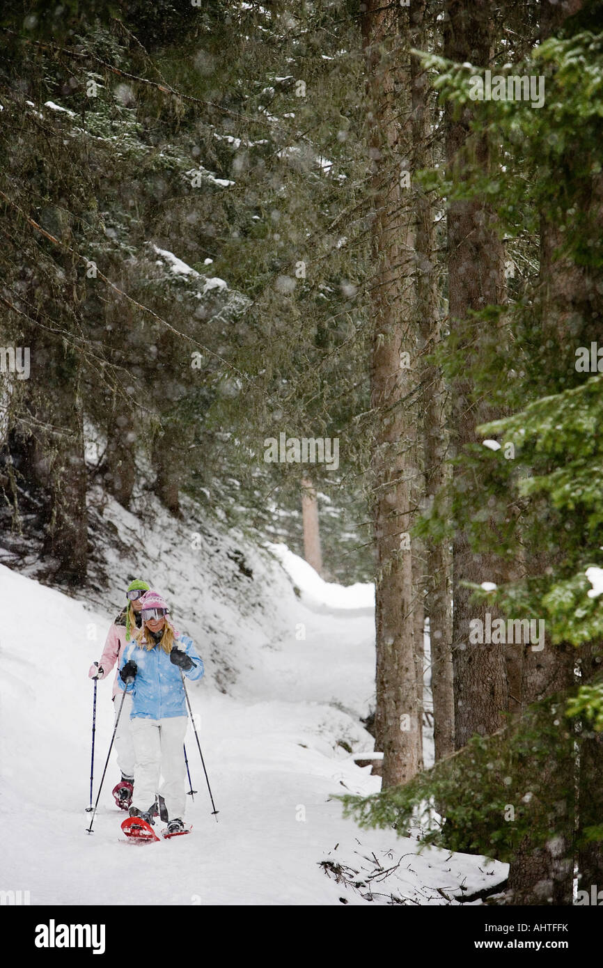 Two young blonde women walking in snow-shoes. Stock Photo