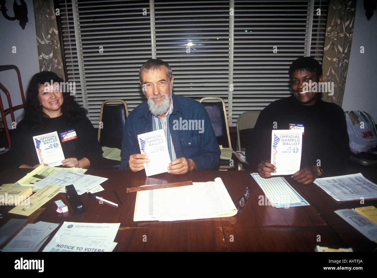Election volunteers displaying Sample Ballots in a polling place CA Stock Photo