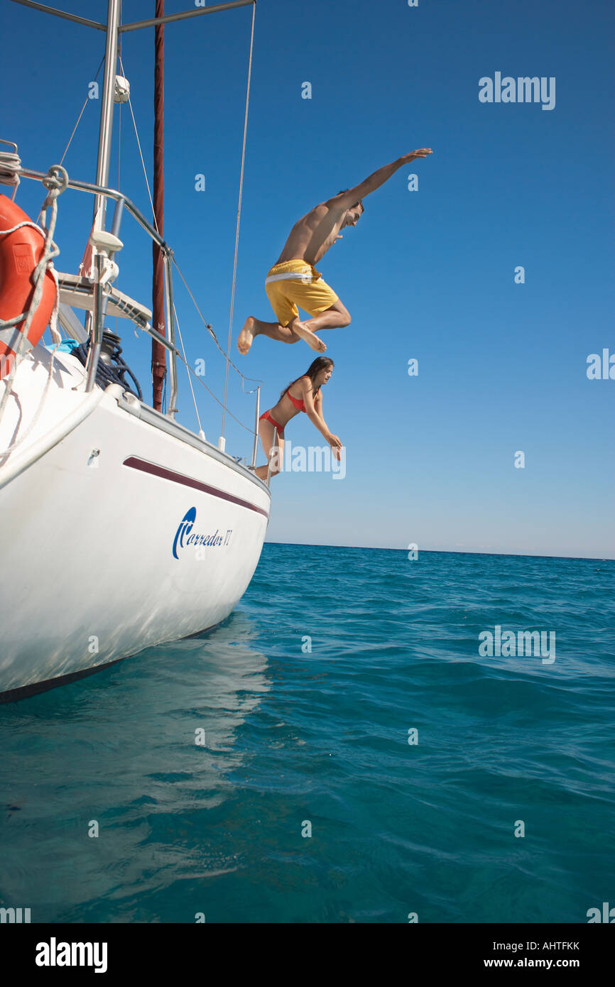 Young couple jumping off yacht into sea Stock Photo Alamy