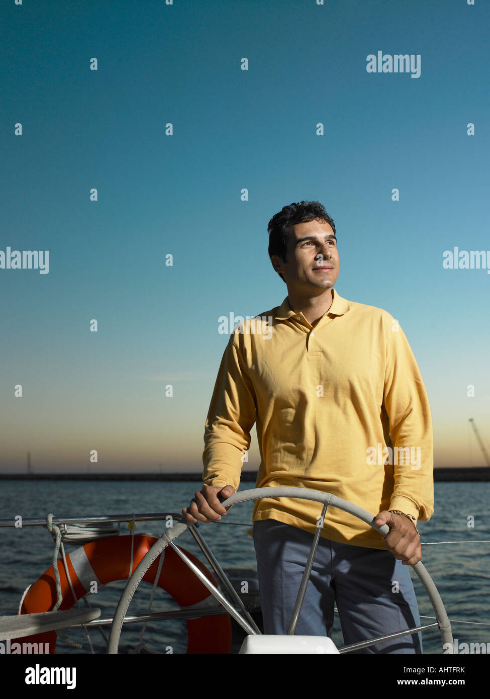 Man steering yacht, smiling Stock Photo