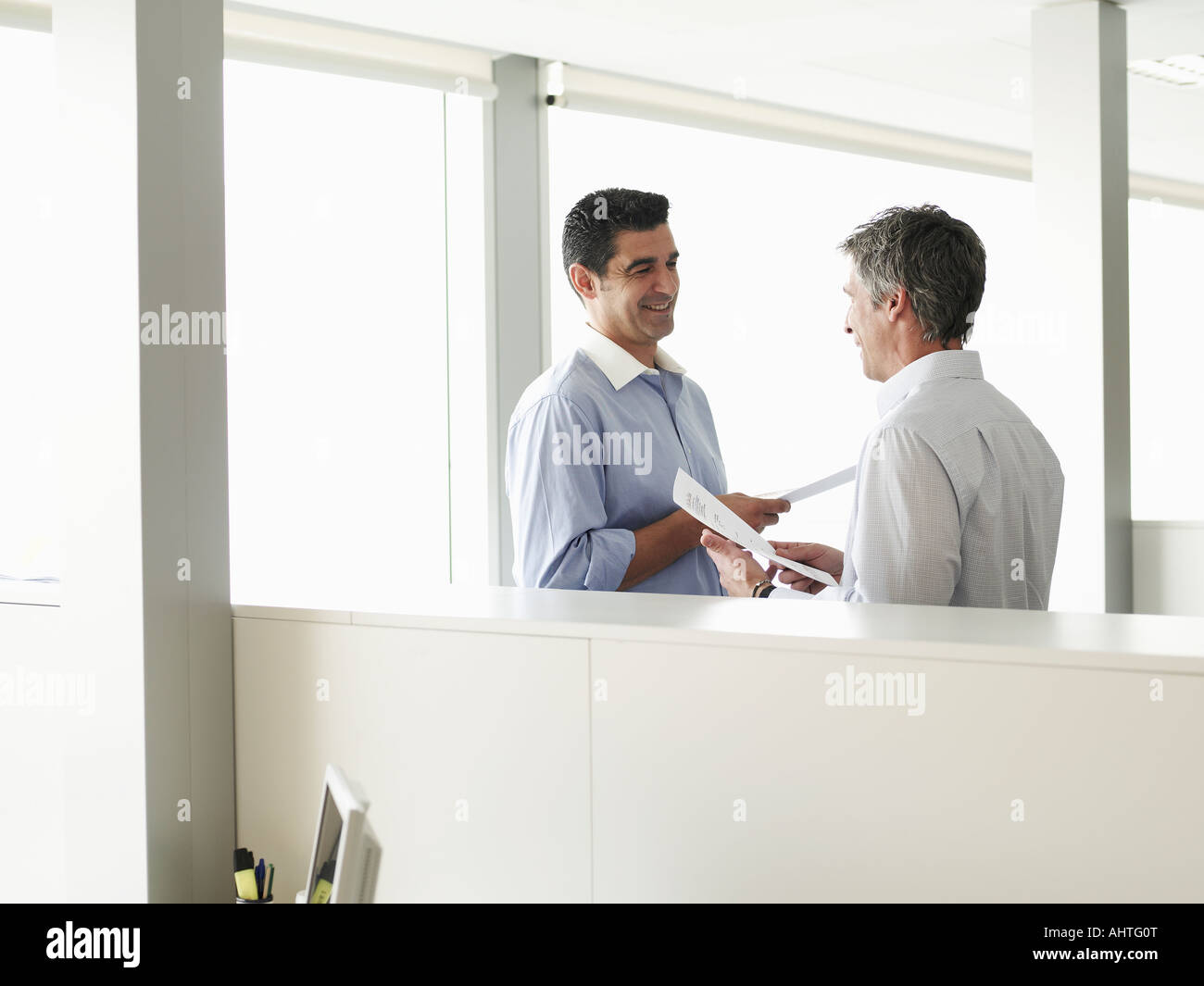 Two businessmen talking in office Stock Photo - Alamy