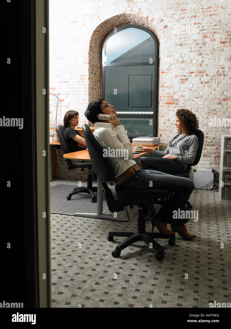 Three businesswomen having a meeting, seen through a threshold ...