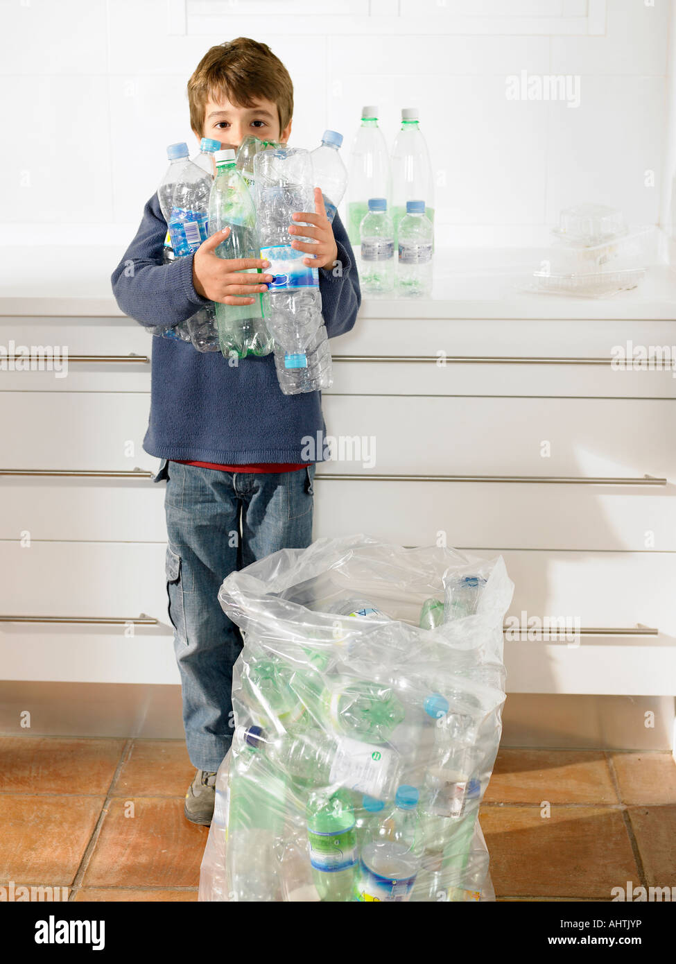 https://c8.alamy.com/comp/AHTJYP/young-boy-holding-an-armful-of-recyclable-plastic-bottles-portrait-AHTJYP.jpg