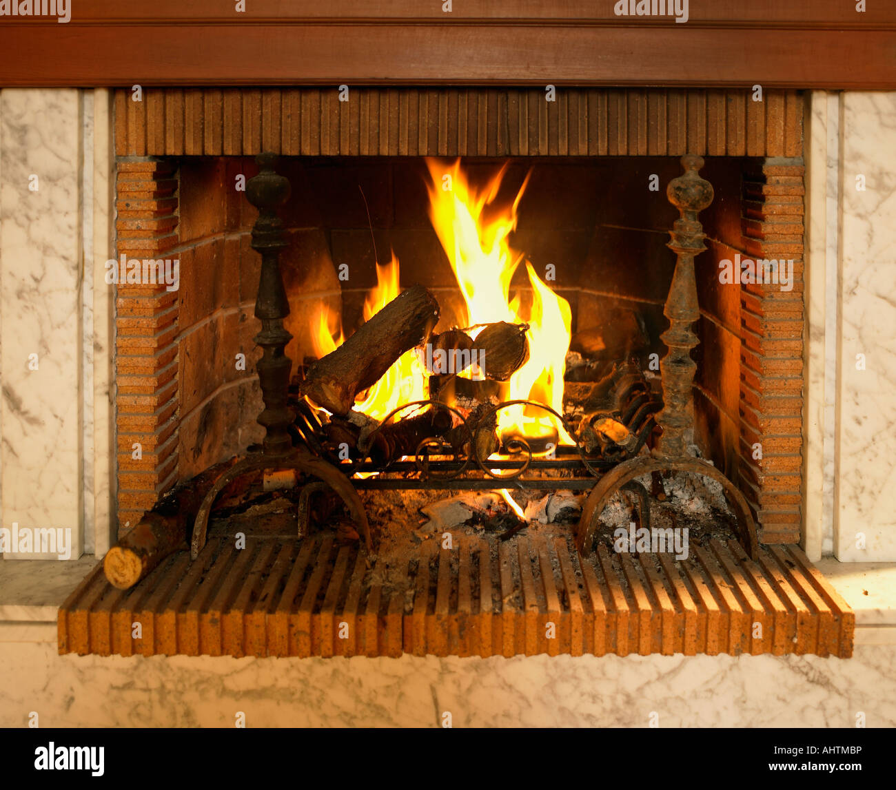 Log Fire Burning In Fireplace With Red Brick Surround Stock Photo