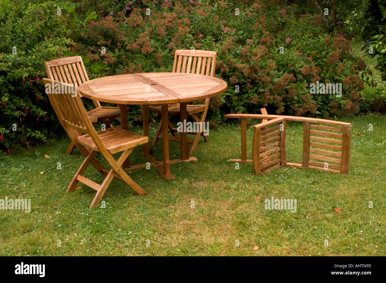 Wooden Table Chairs in a Garden Stock Photo - Alamy