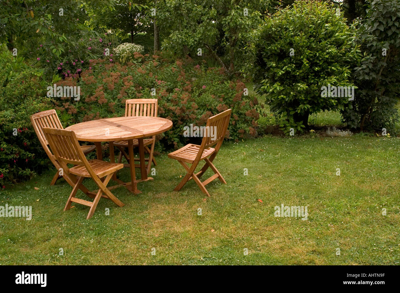 Wooden Table Chairs in a Garden Stock Photo - Alamy