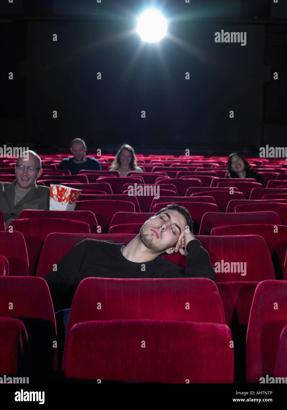 Young man asleep in cinema Stock Photo