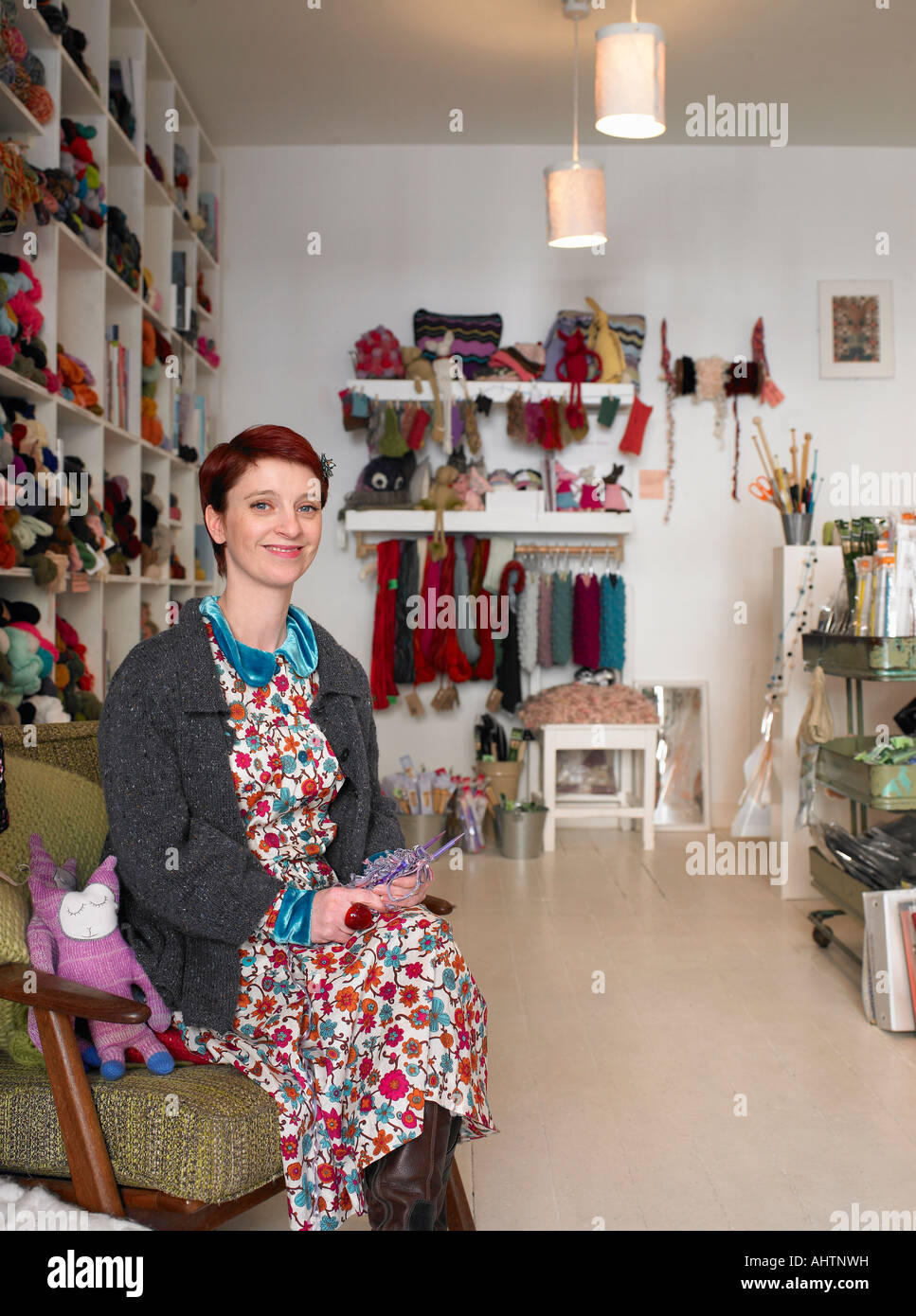 Woman sitting in craft shop, smiling, portrait Stock Photo
