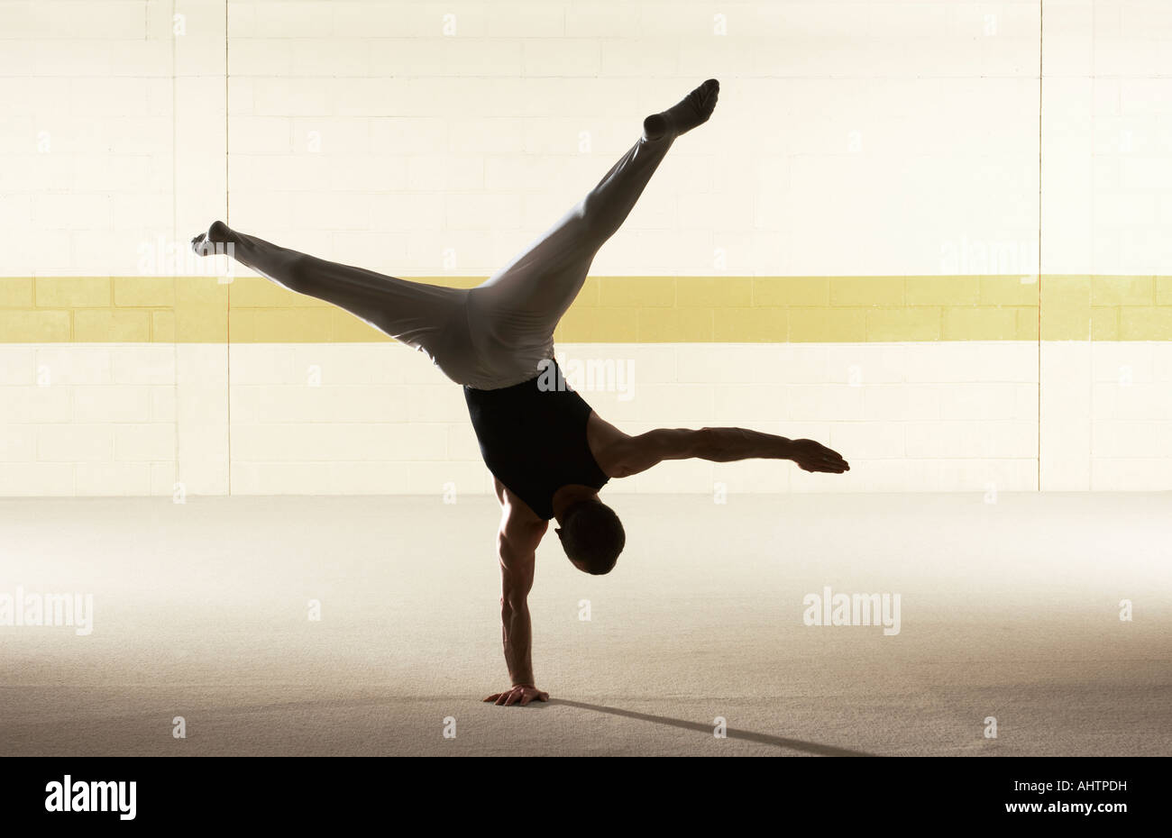 Male gymnast balancing on one hand, rear view Stock Photo Alamy