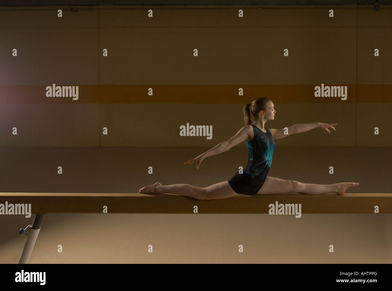 Teenage gymnast (16-18) performing splits on balance beam Stock Photo