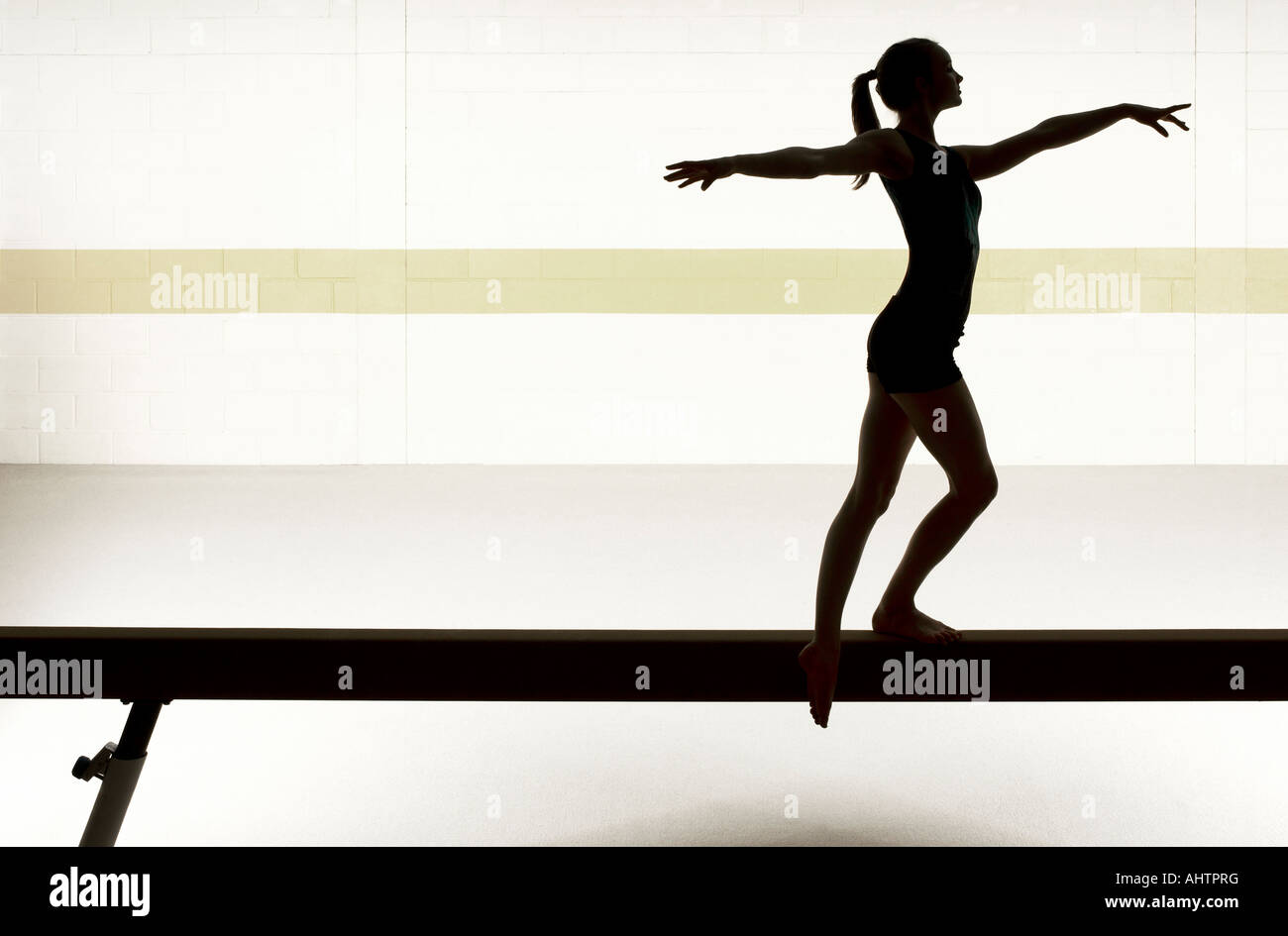Teenage gymnast (16-18) performing on balance beam Stock Photo