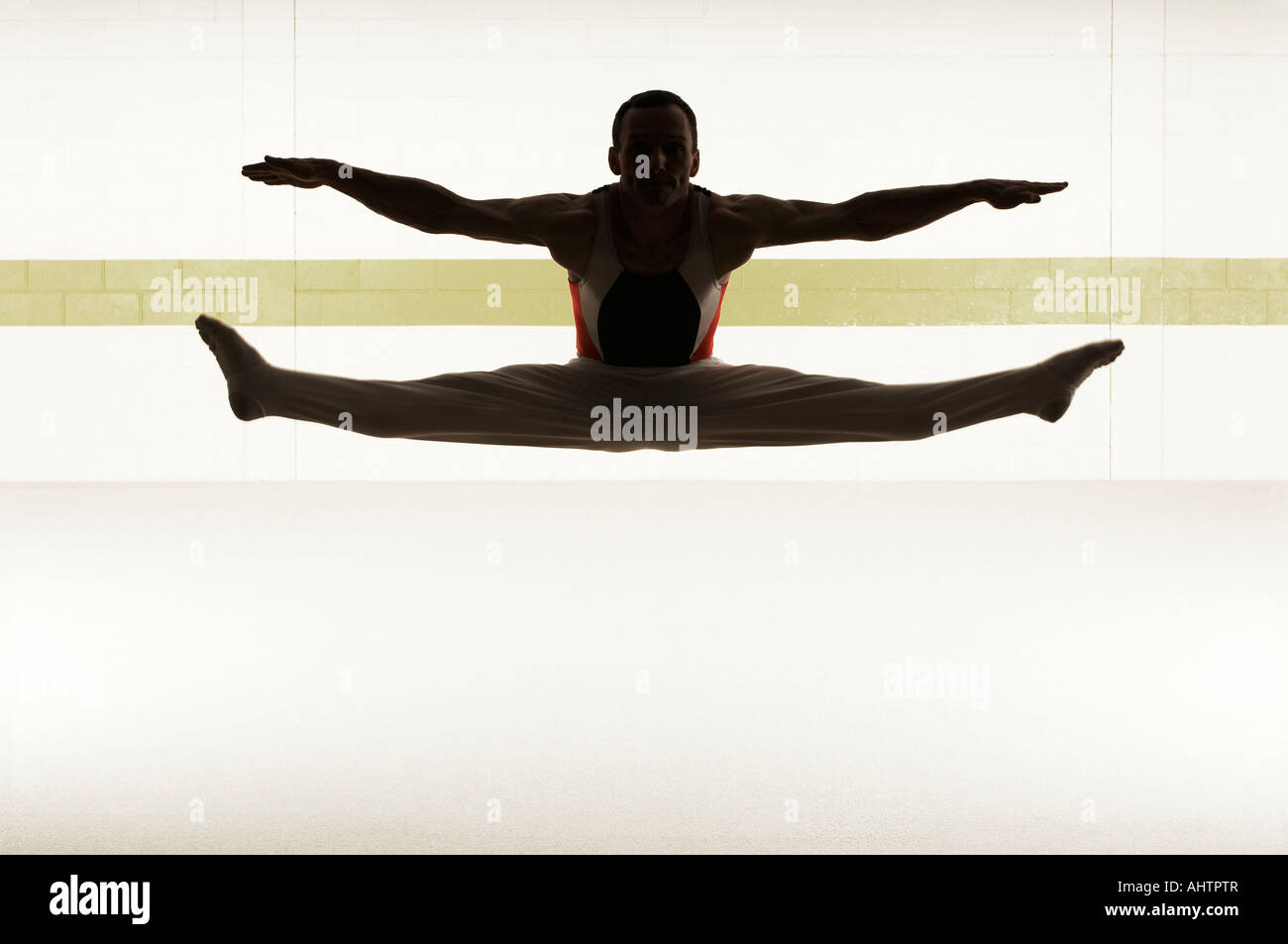 Male gymnast performing splits in floor exercise Stock Photo