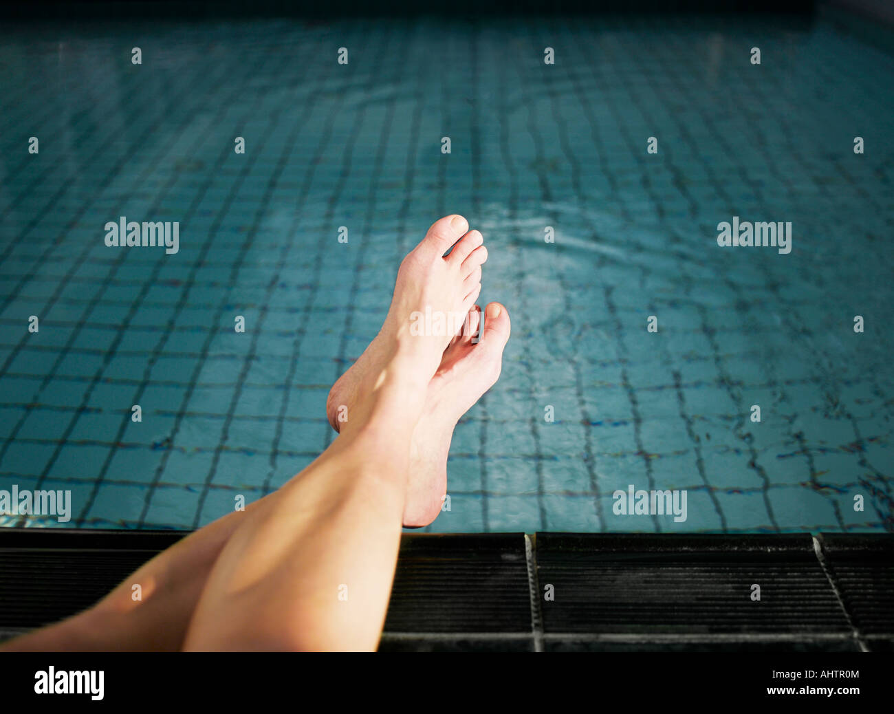 Woman with feet in swimming pool, low section Stock Photo - Alamy