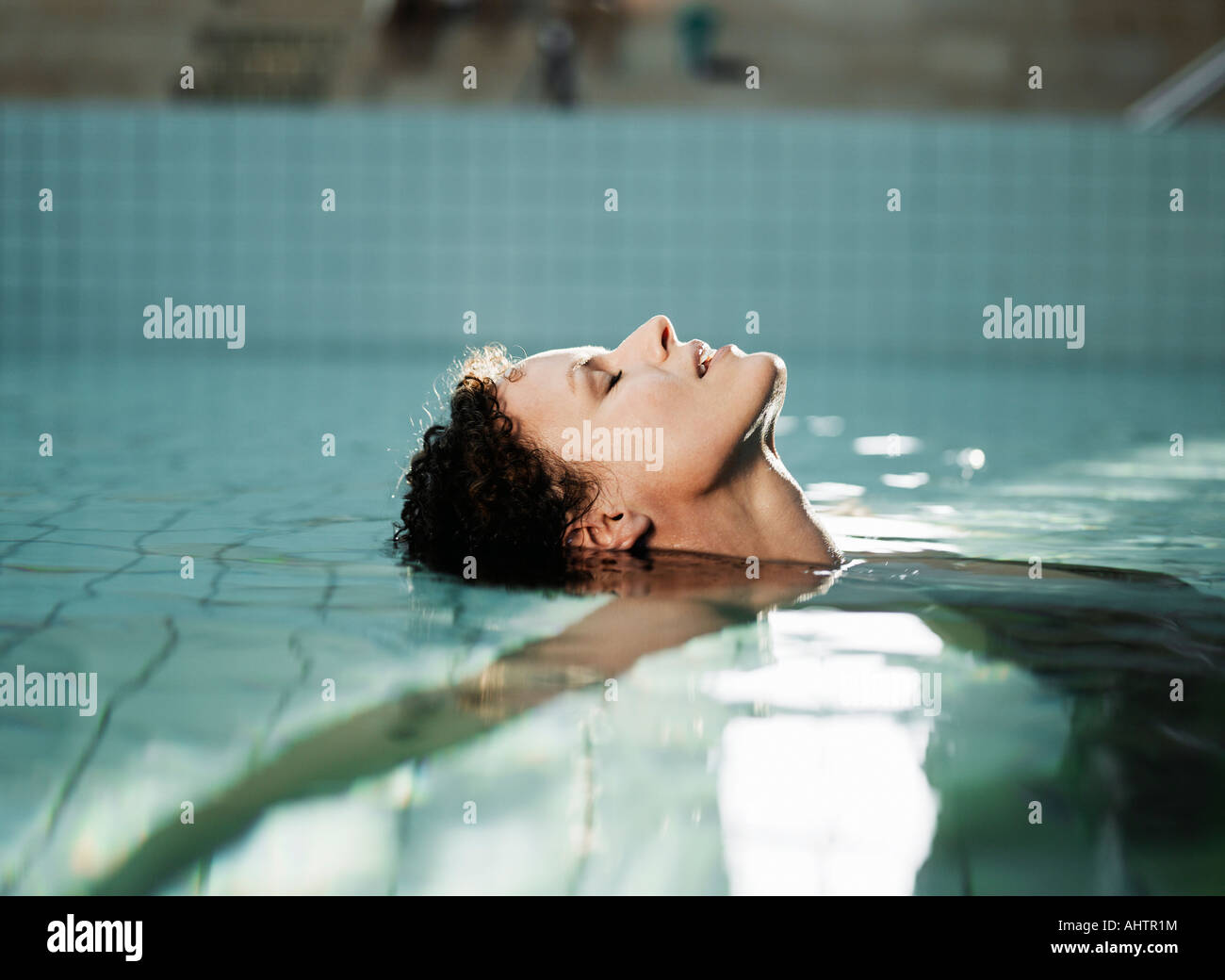 Woman lying in water, side view Stock Photo - Alamy