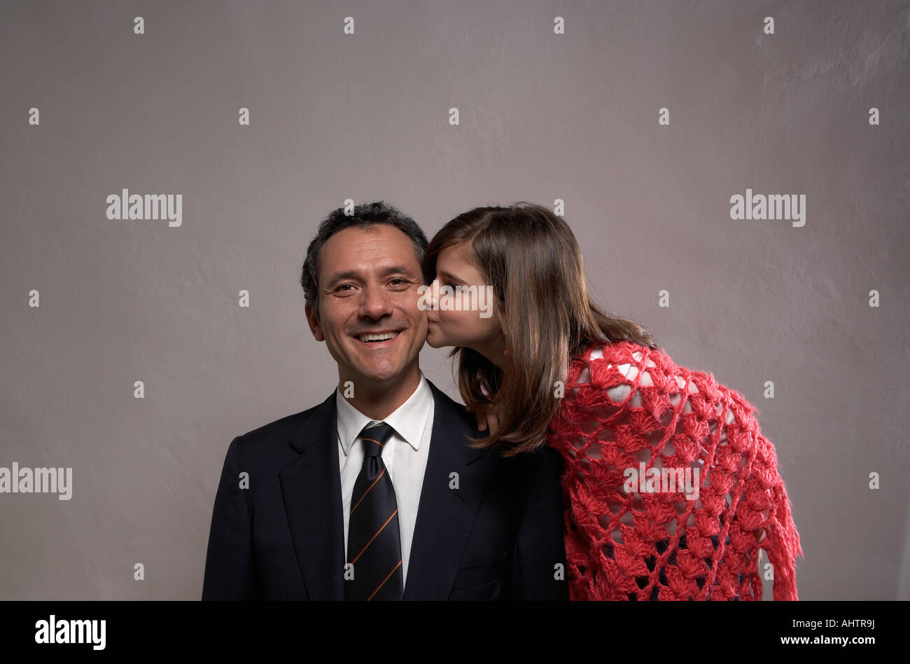 Daughter (9-11) kissing smiling father on cheek Stock Photo