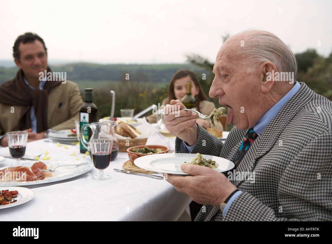 Three generation family eating outdoors Stock Photo
