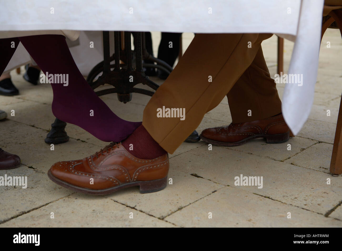 Woman flirting with man under table Stock Photo