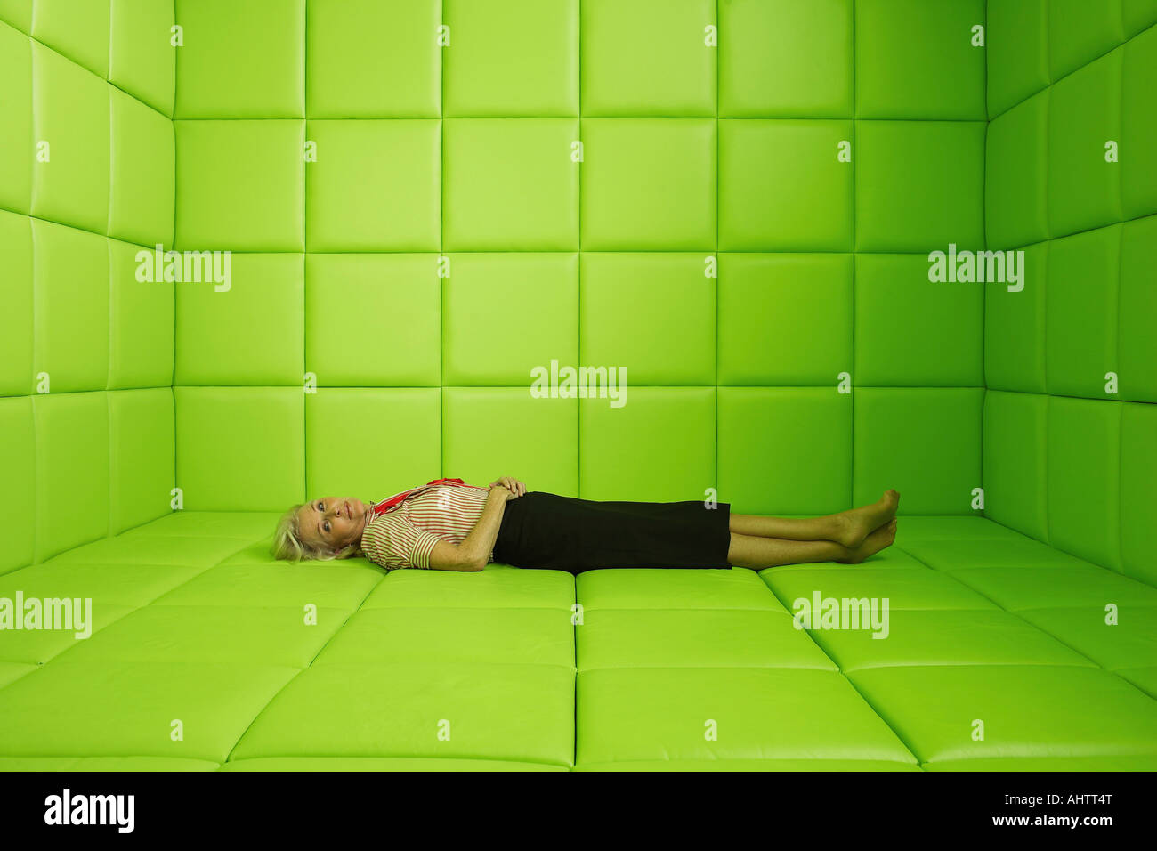 Woman resting in green padded cell Stock Photo