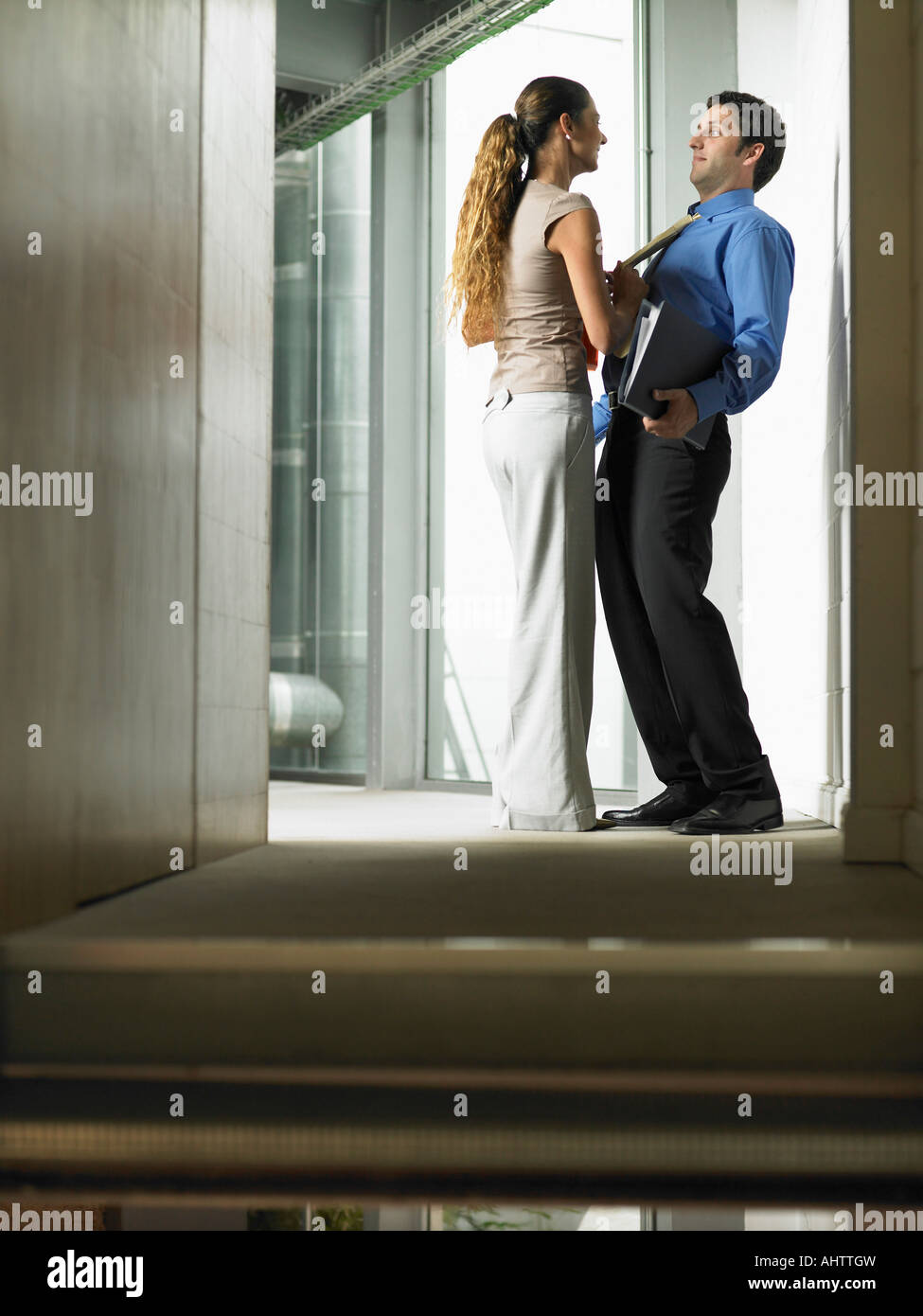 https://c8.alamy.com/comp/AHTTGW/a-woman-talking-to-a-man-in-a-hallway-AHTTGW.jpg