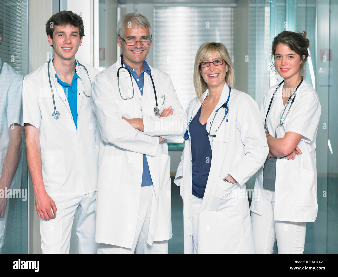 Group shot of four doctors in hospital lobby. Stock Photo