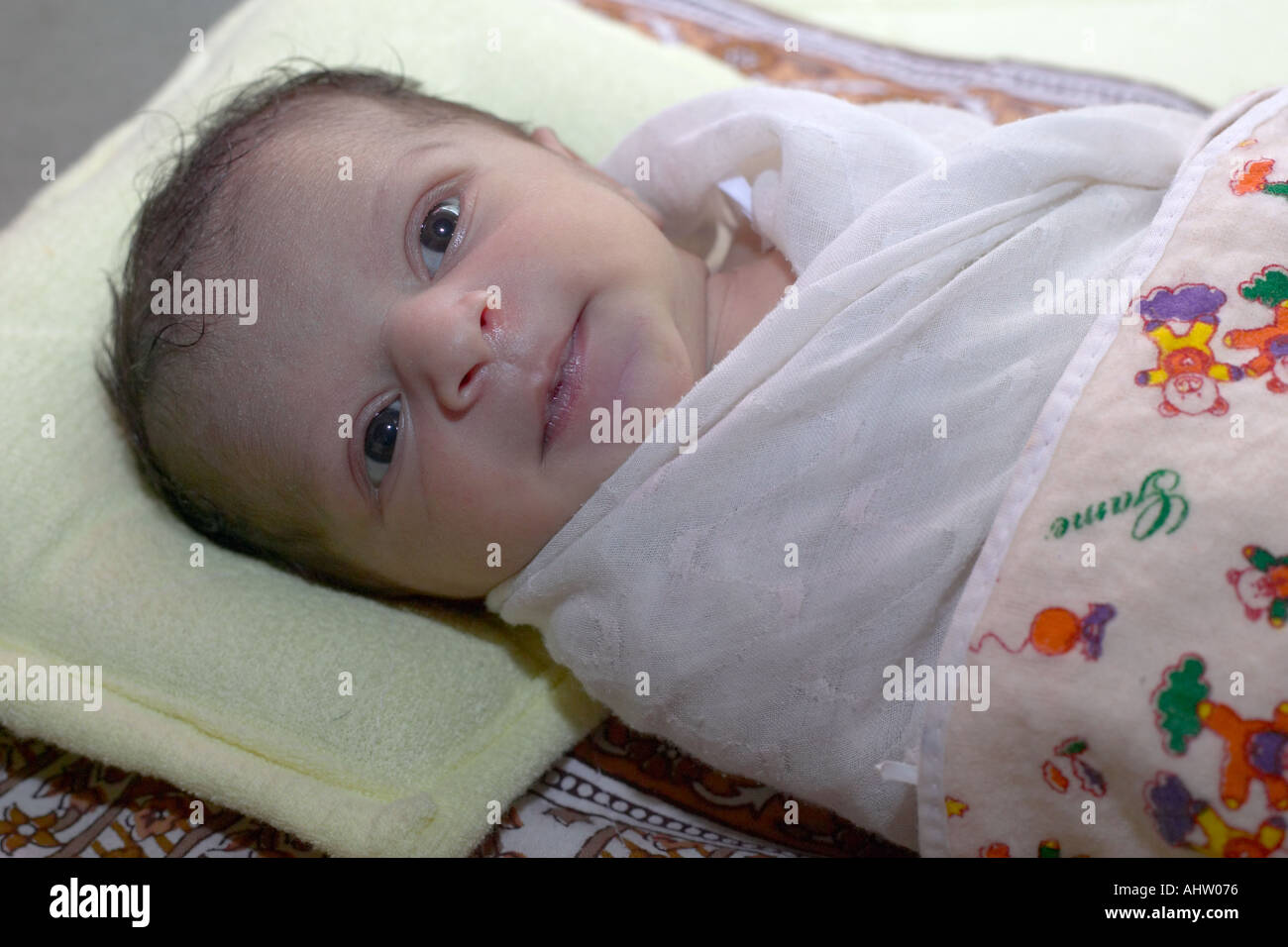 AAD 91769 Just born ten day old new Indian Baby Girl child lying wrapped on bed Model Released Stock Photo