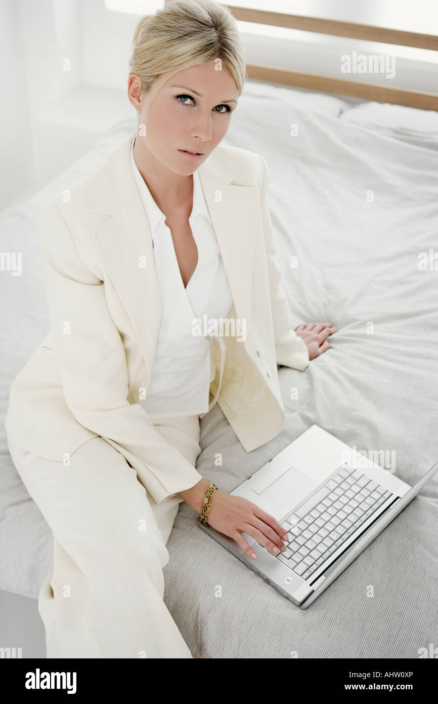 Woman with laptop on bed Stock Photo - Alamy