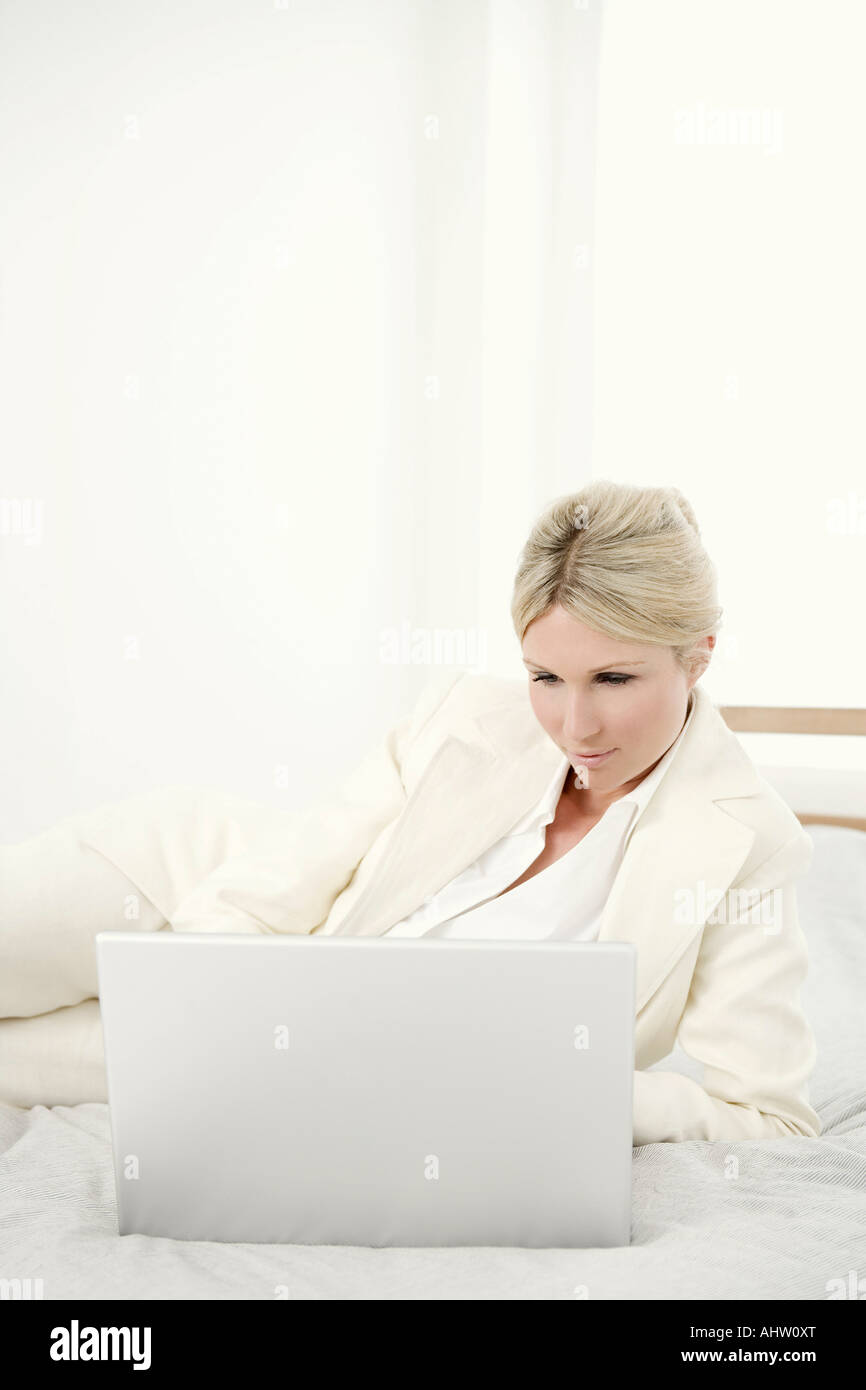 Woman with laptop on bed Stock Photo - Alamy