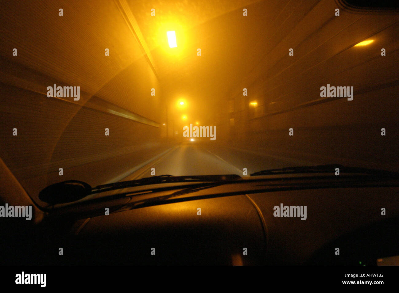 Hazy view through windscreen of a car at foggy luminescent streetlights