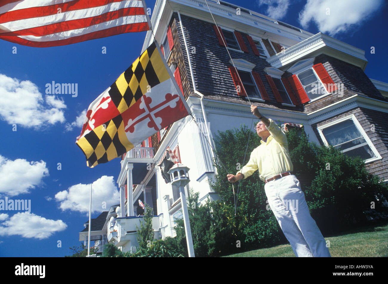 Man Raising American and Maryland Flags Cape May New Jersey Stock Photo