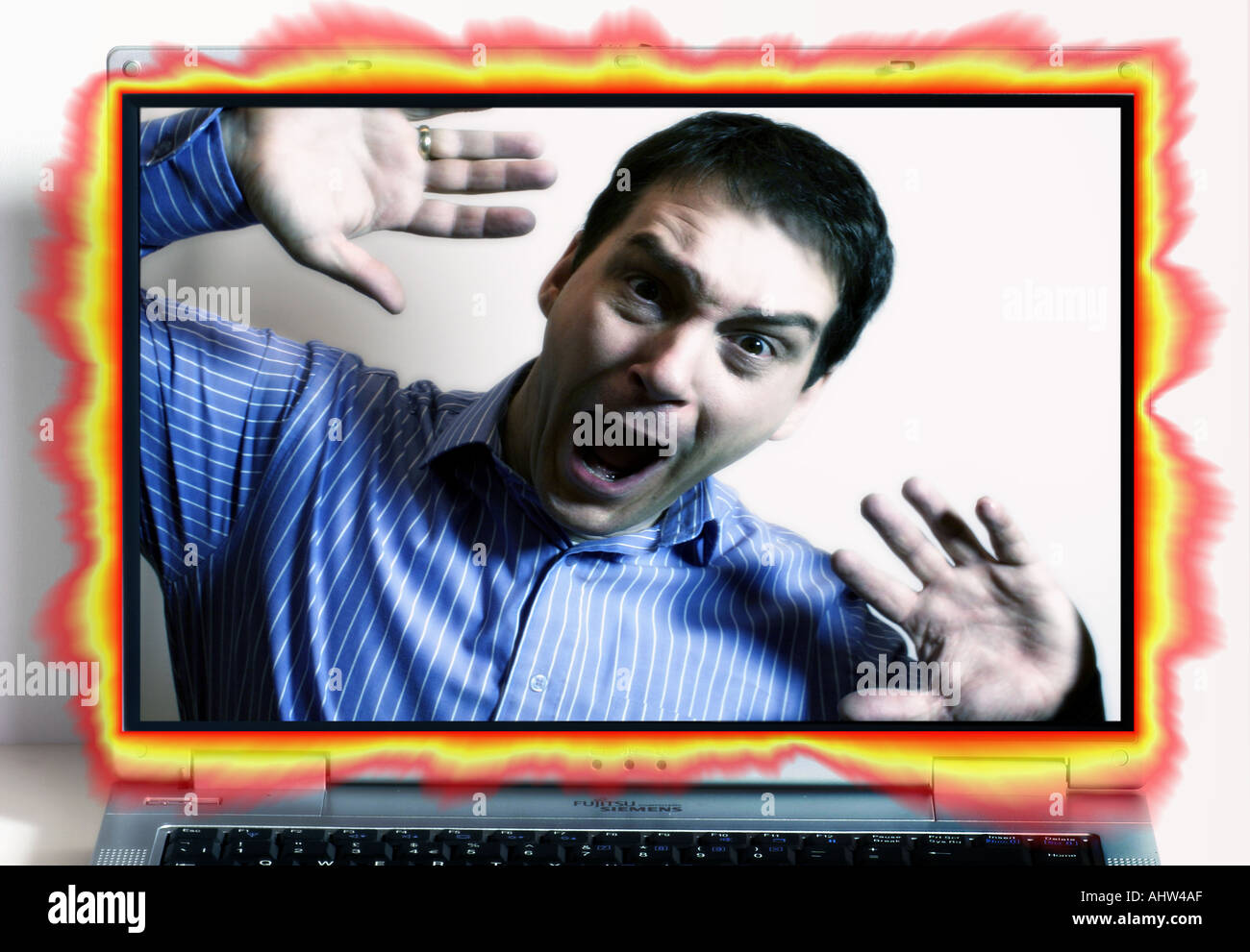 Composite showing man behind glowing notebook screen Stock Photo
