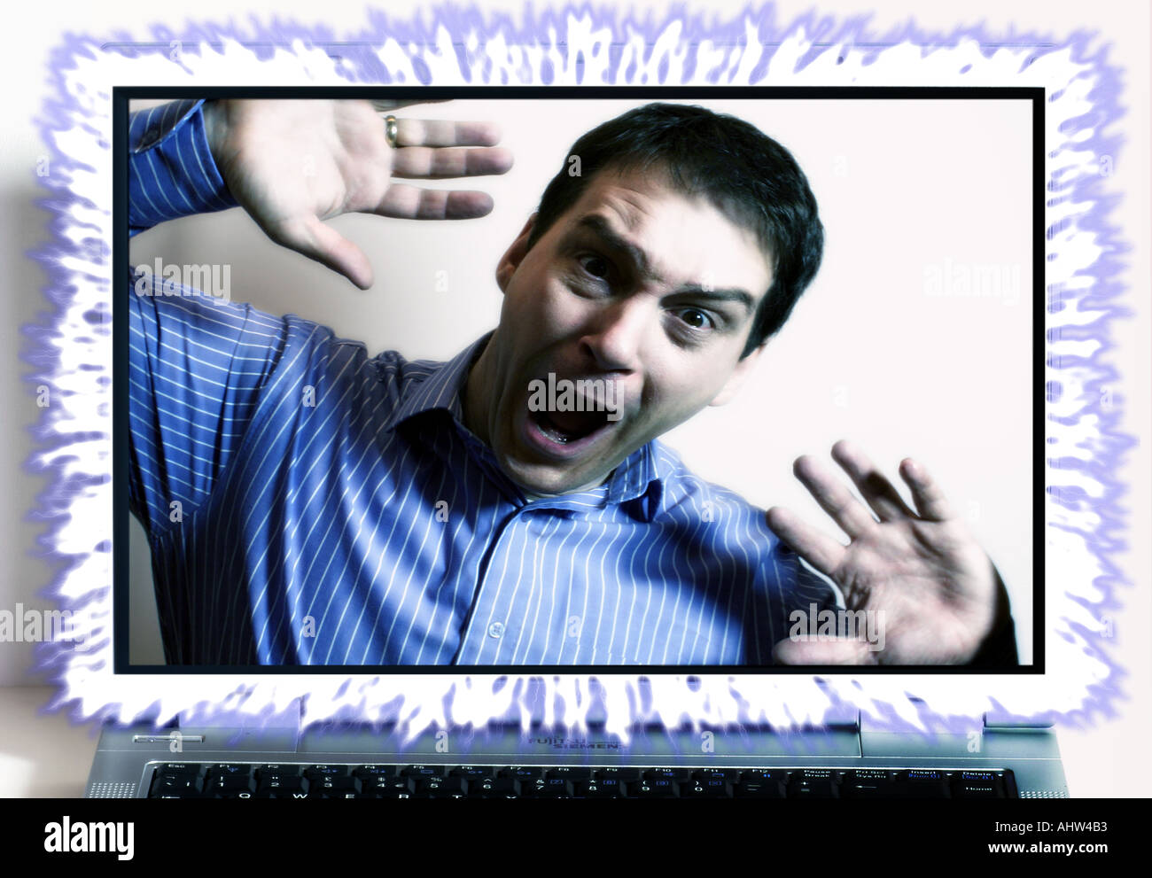 Composite showing man behind glowing notebook screen Stock Photo