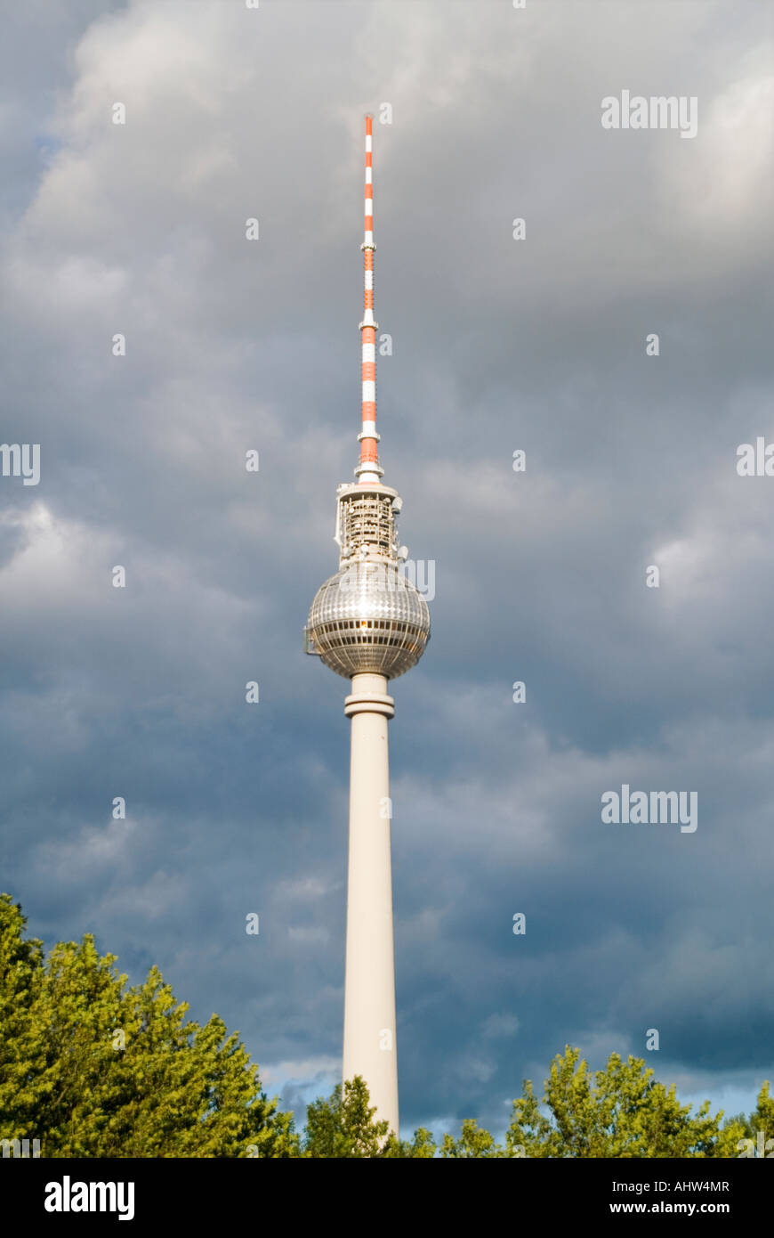 Vertical view of the TV tower 'Fernsehturm' against dark grey storm clouds. Stock Photo