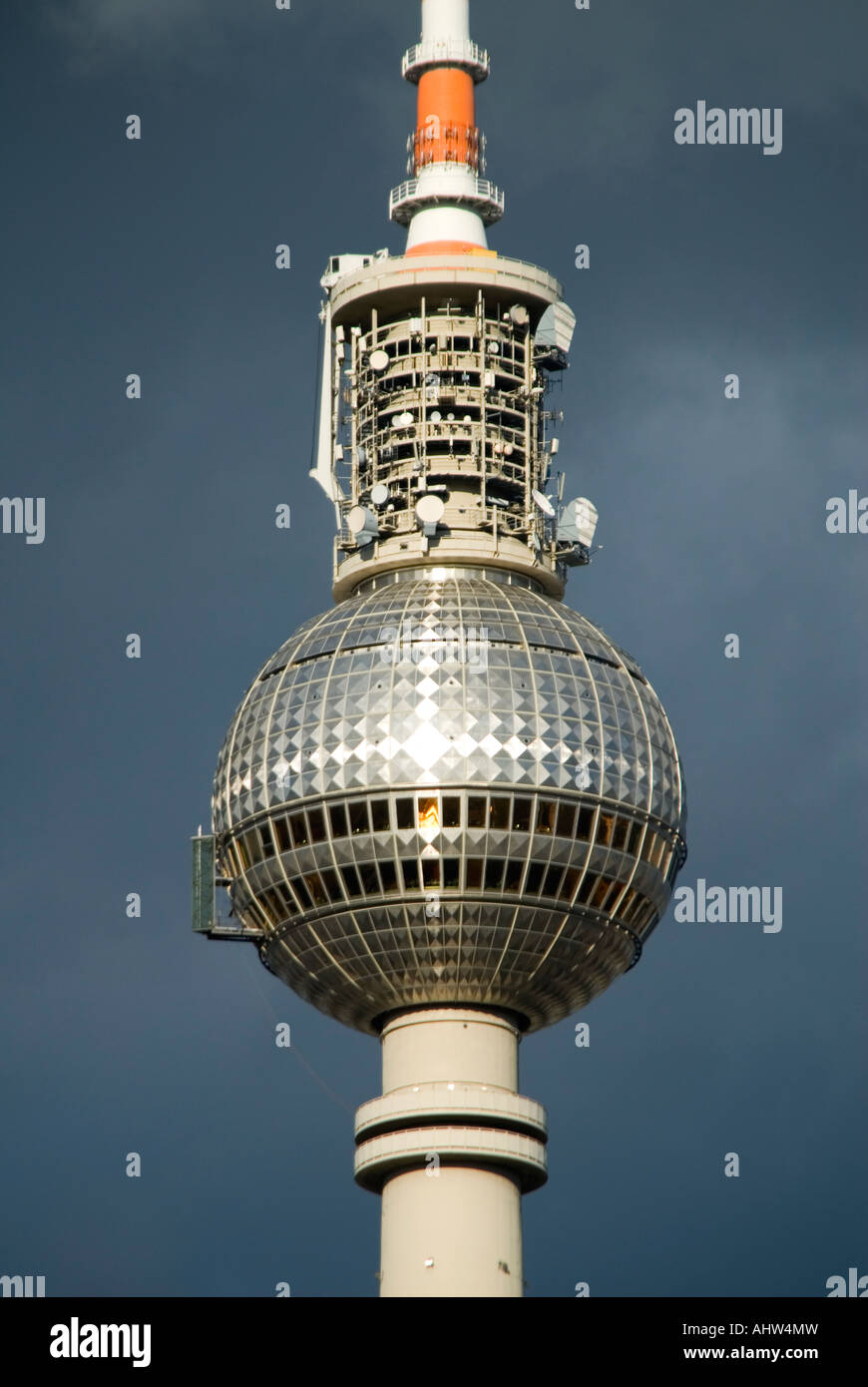 Vertical close up of the TV tower 'Fernsehturm' against dark grey storm clouds. Stock Photo
