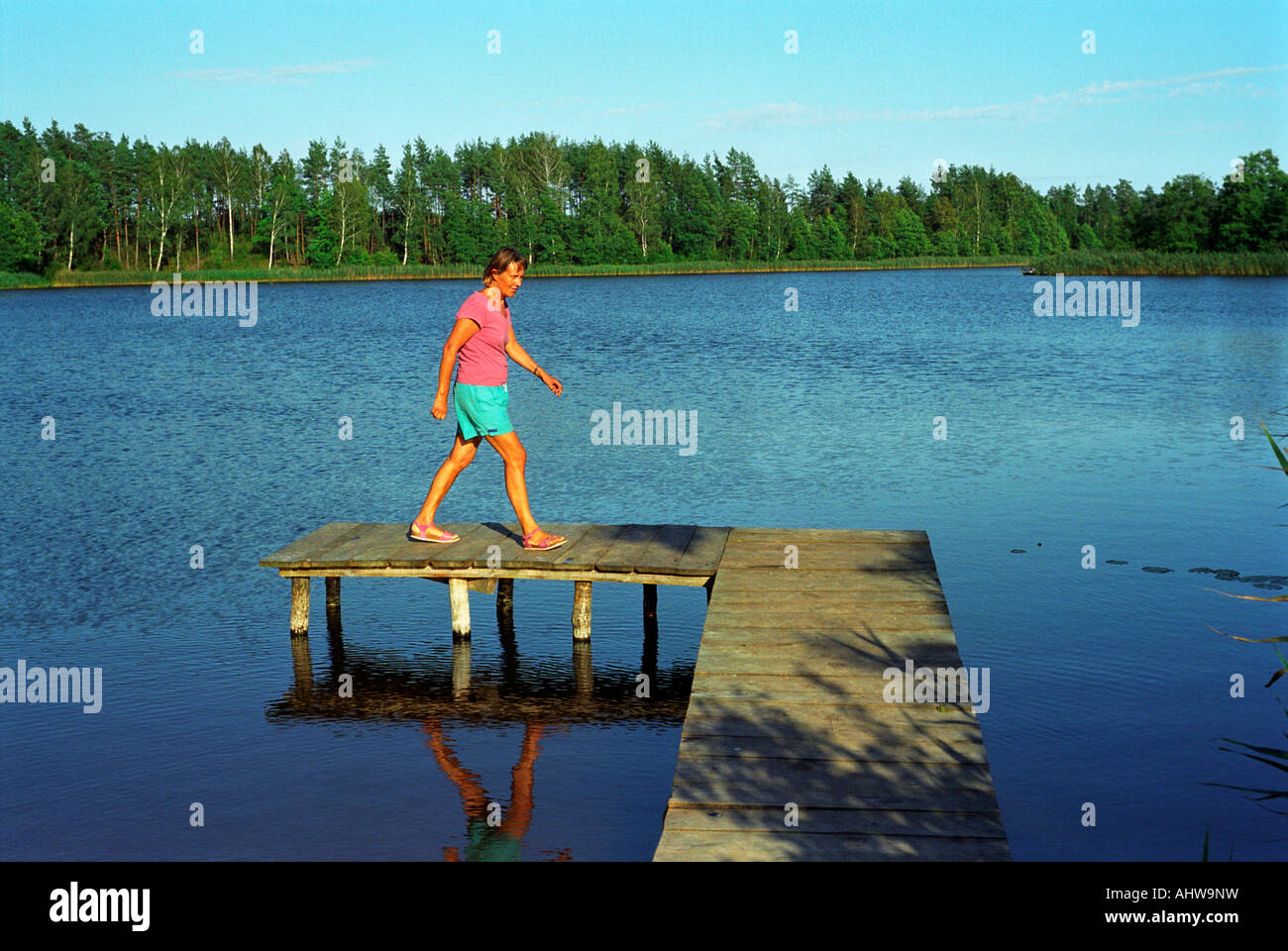 Woman walking on a jetty, Suwalki, Poland Stock Photo