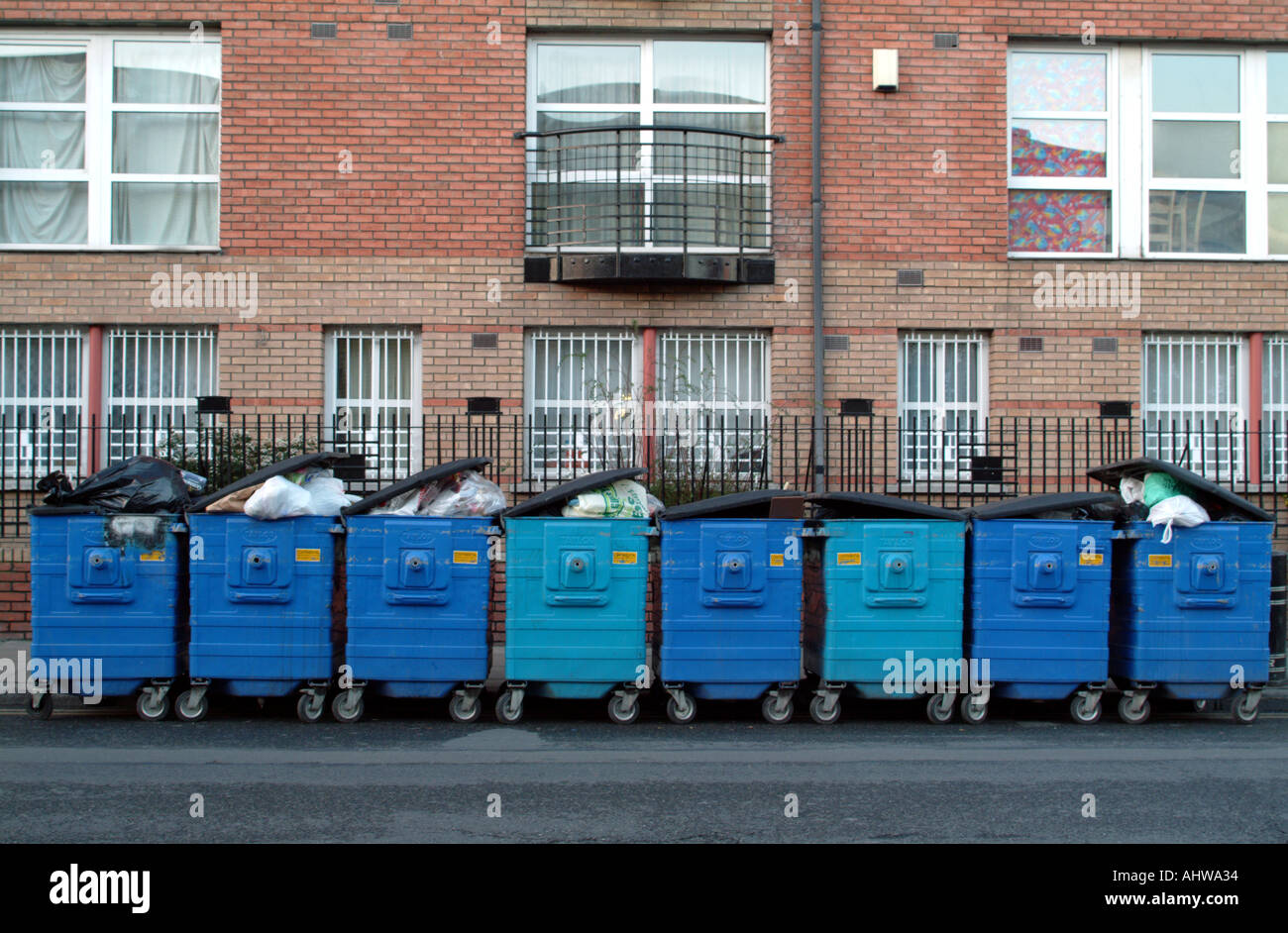 Light and dark blue refuse bins line a Dublin street in the city centre