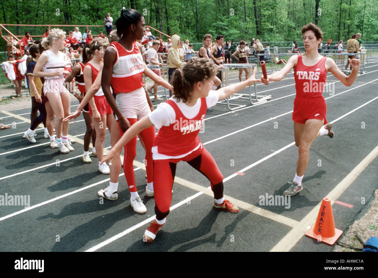 The baton pass in a girls track meet shows the importance of teamwork