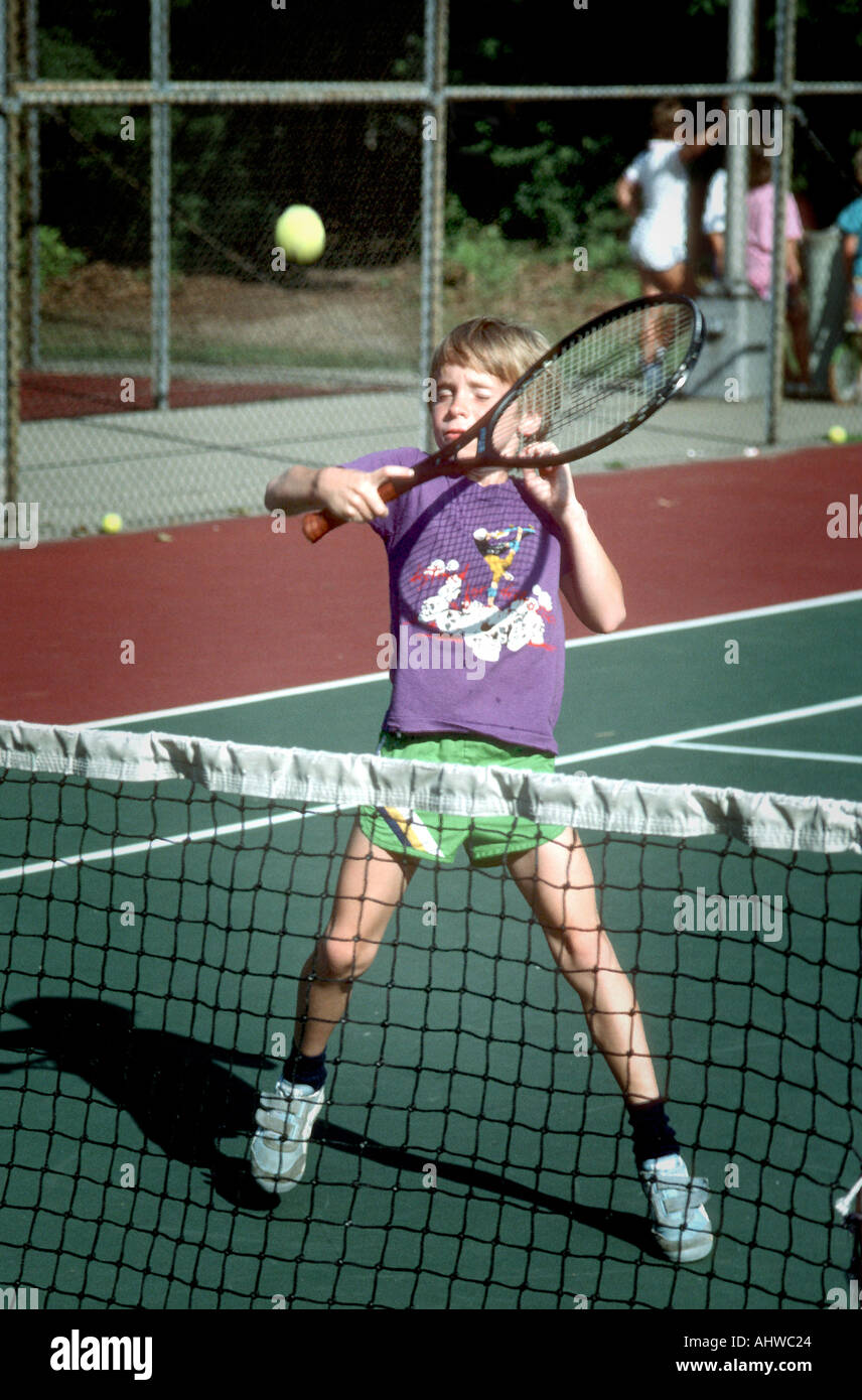 A 7 year old boy takes tennis lessons Stock Photo