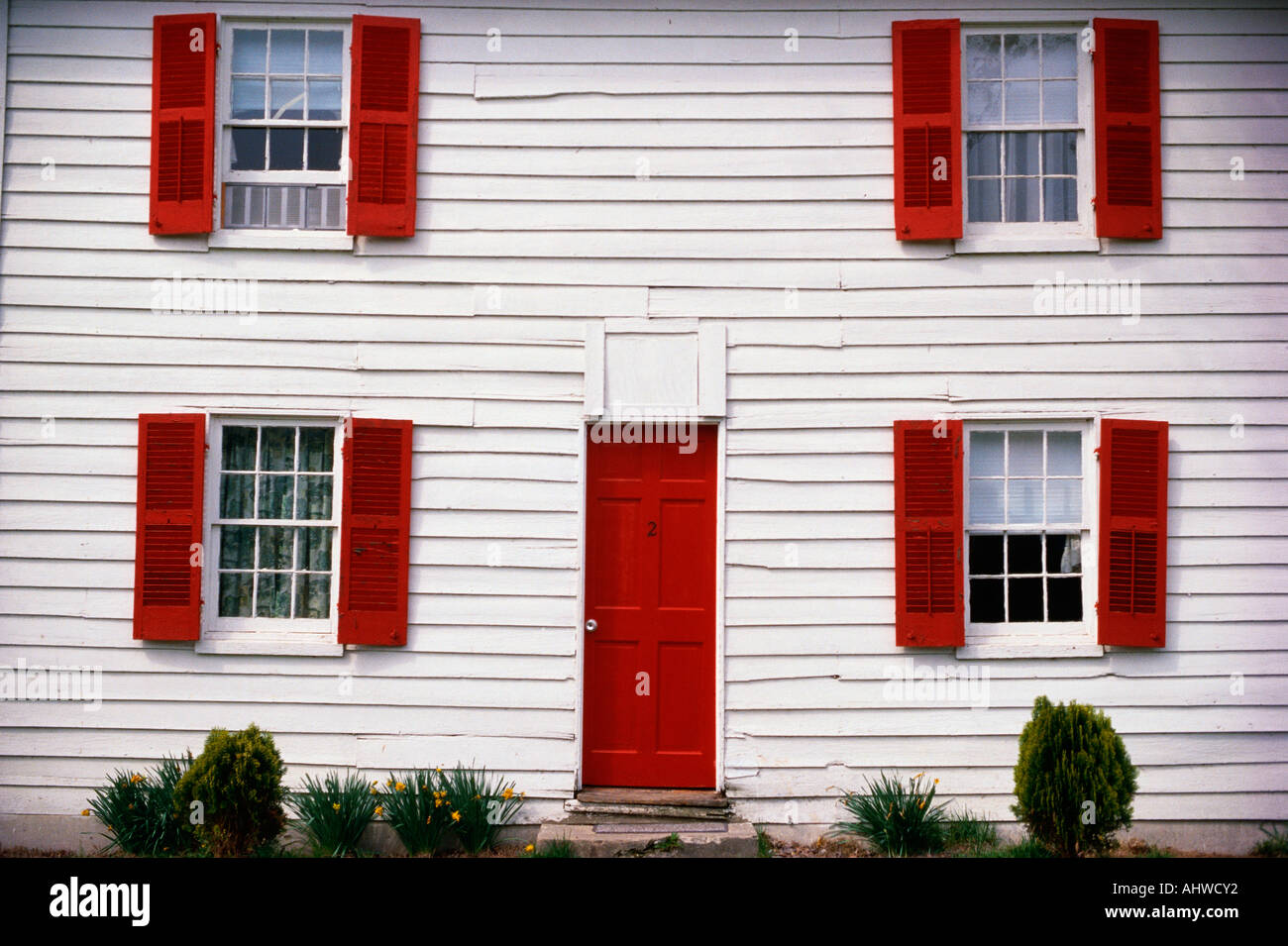 This Is A Close Up Of A White House With Red Shutters The Front