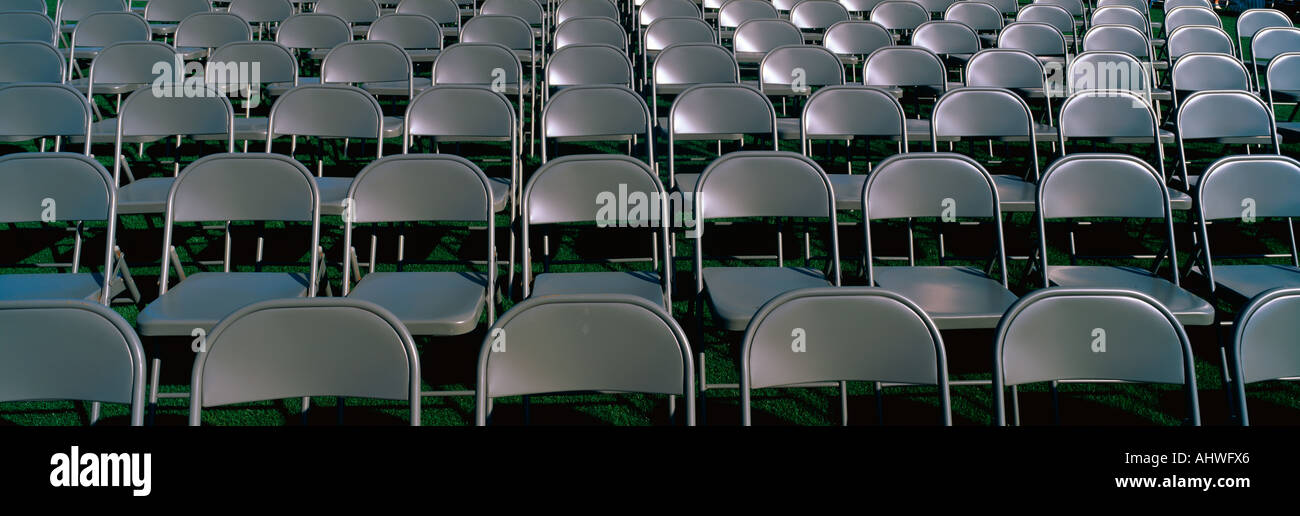 These are empty grey folding chairs awaiting the crowd to attend the U