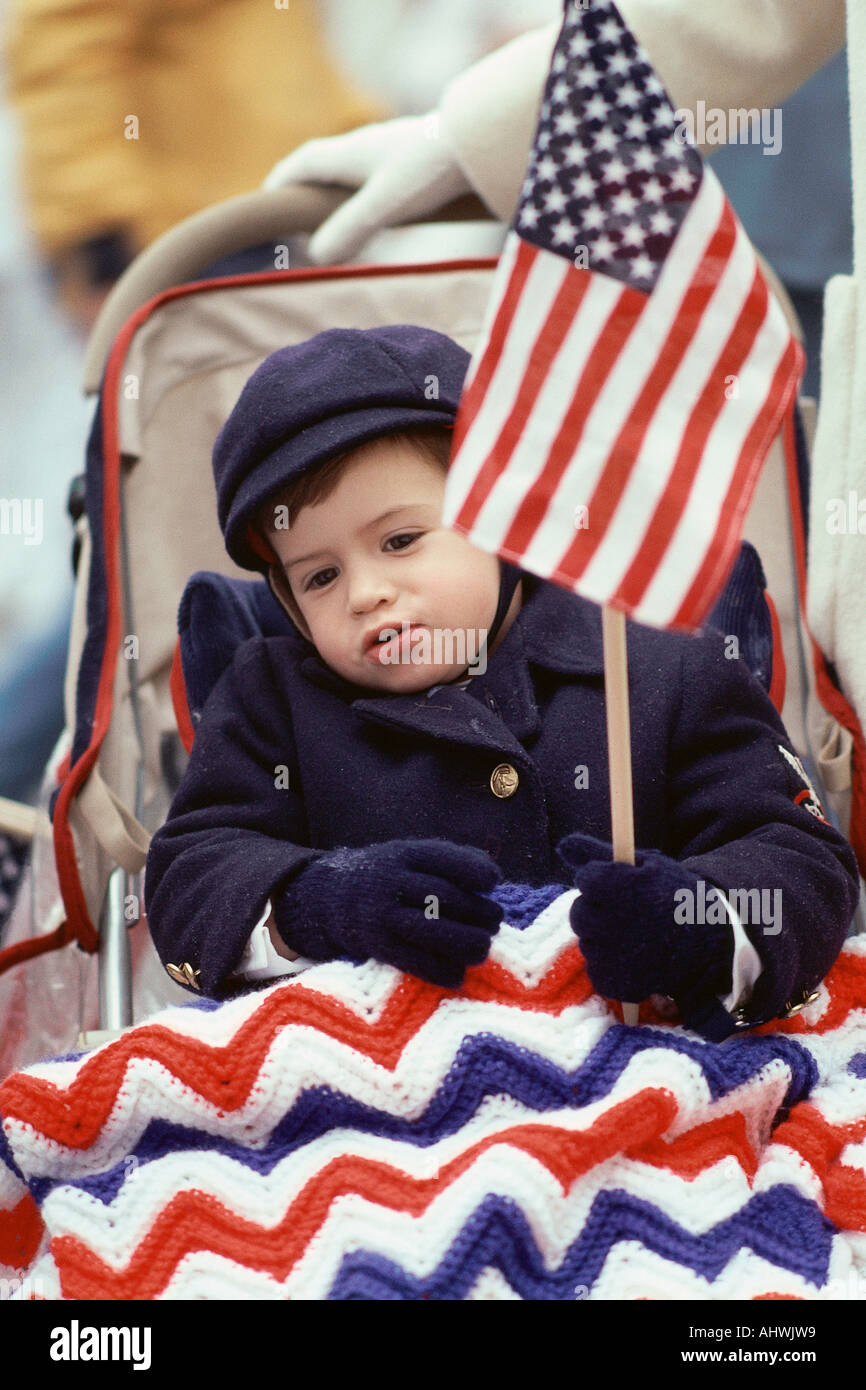 Toddler holding American flag in baby carriage Stock Photo