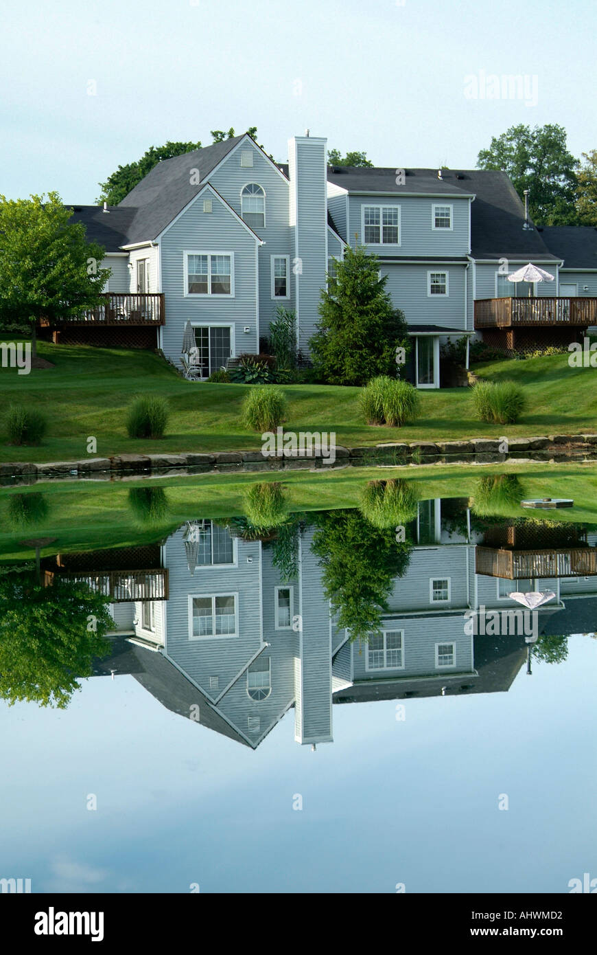 Reflections in a pond of upscale homes in a residential neighborhood