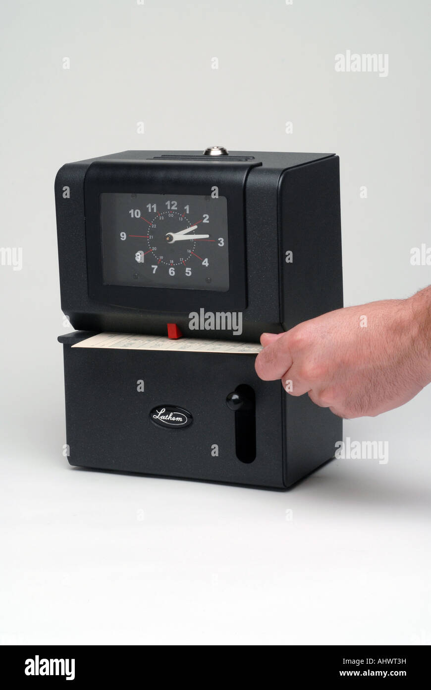 Electronic time clock on white seamless with hand inserting time card