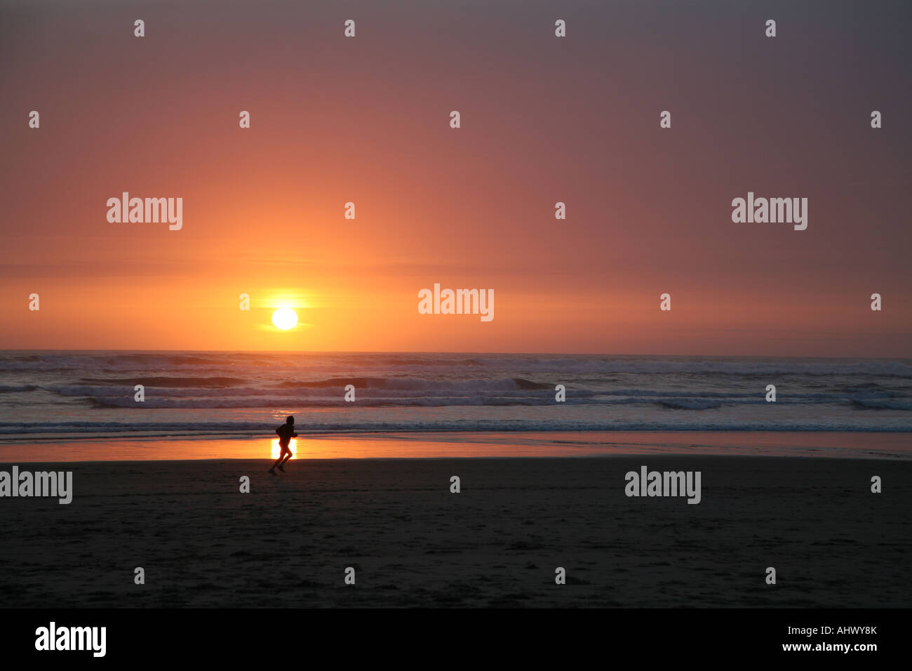A single distant beach scene with a person on the Pacific Stock Photo
