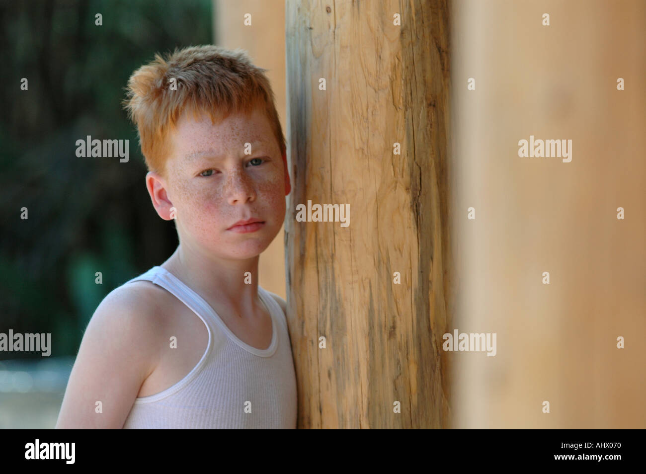 Sad boy  at wooden door and post Stock Photo