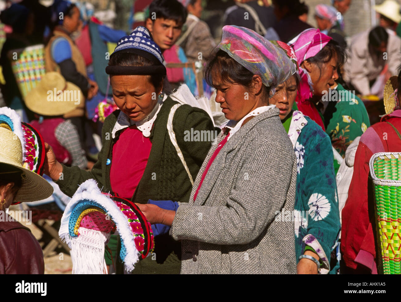 China Yunnan Shaping market women buying Bai head dress symbolising the four natural elements of air earth fire water Stock Photo